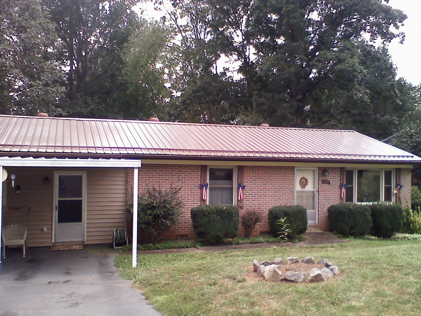 Bronze metal roof and carport on a brick ranch home — Roof Repair work by our crew in Whitmire